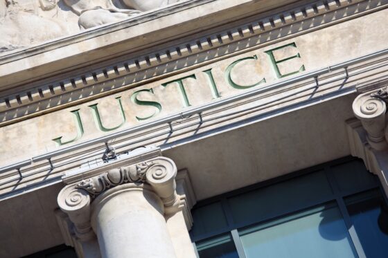 The word Justice on a Courtroom Building.