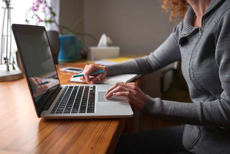Woman doing research on laptop from home office