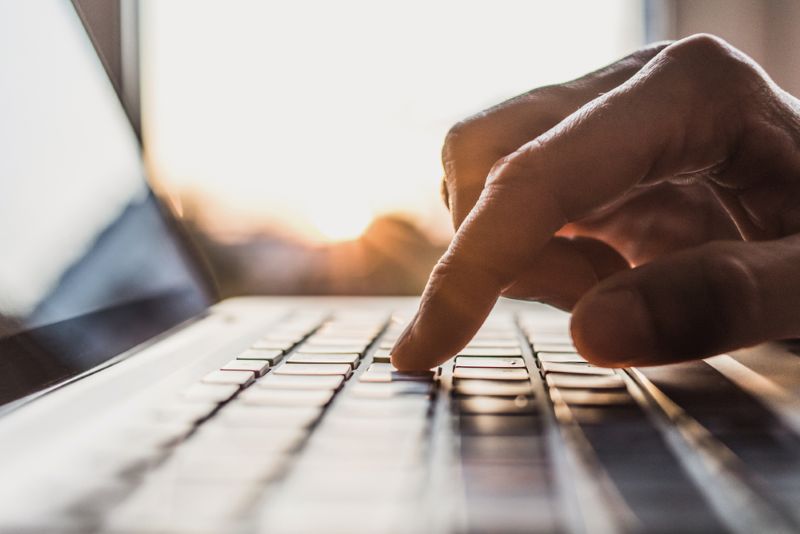 Closeup of a person typing on a laptop