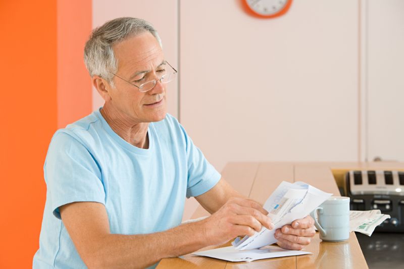 Older man opening and reading his mail