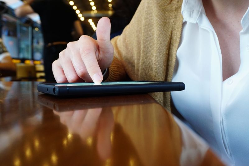 Woman scrolling on her phone in a restaurant
