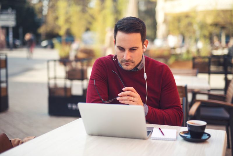 Man working from his laptop at an outdoor cafe